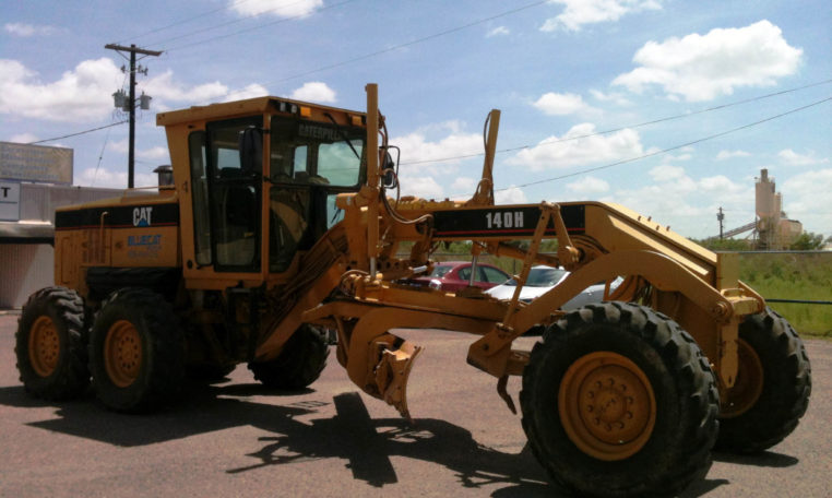 A Yellow Truck With Digging Tool Attached