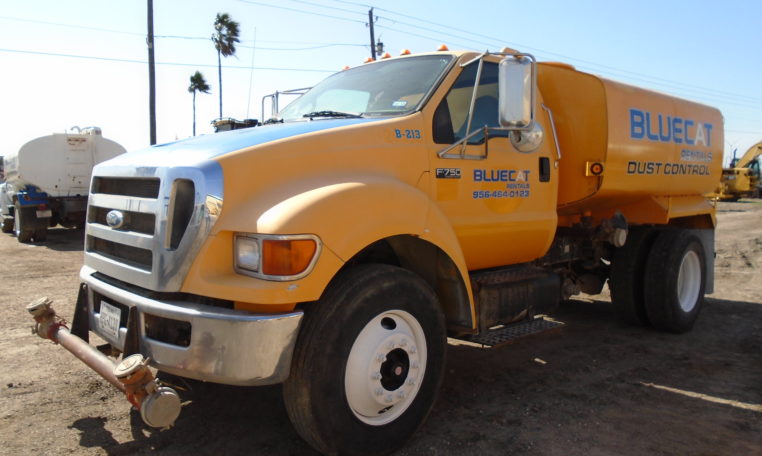 A Yellow Blue Cat Water Truck Left Front Wheel View One