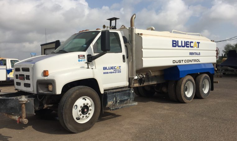 A Blue Cat Water Truck With a Front Attachment Unit