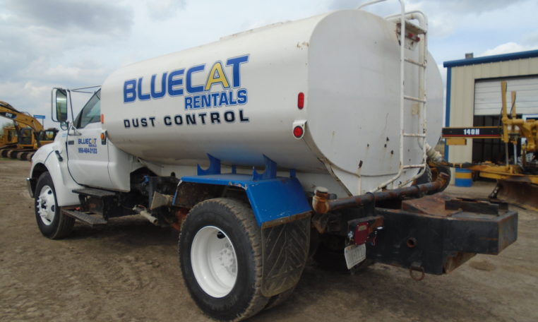 A White Dust Control Water Truck Back With Blue Lettering