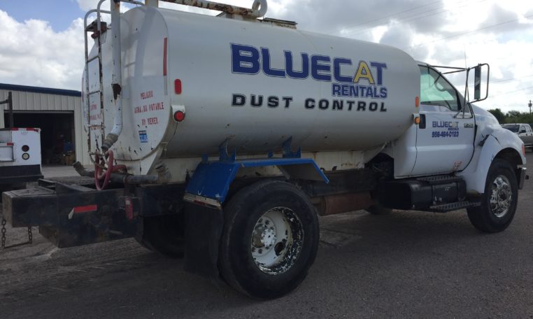 A White Water Truck With Blue Words Painted