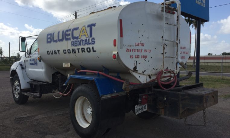 A White Water Truck With Blue Words Painted Back